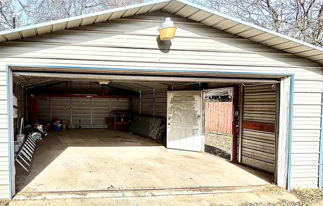 a backyard of a house with large trees and table and chairs