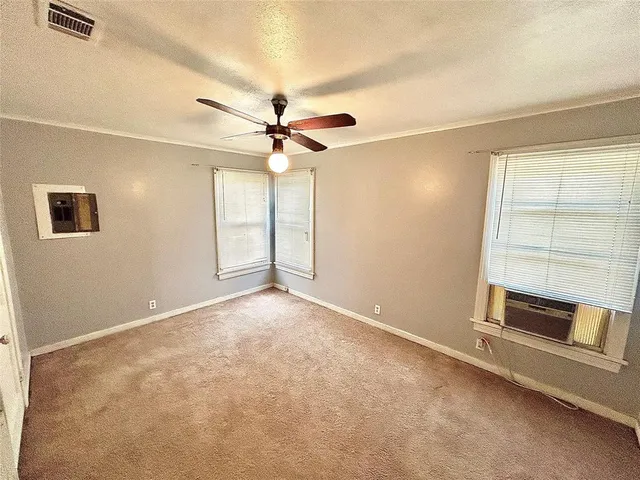 an empty room with windows and fan