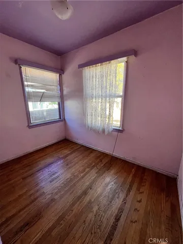 a large kitchen with granite countertop a sink a stove wooden floor and cabinets