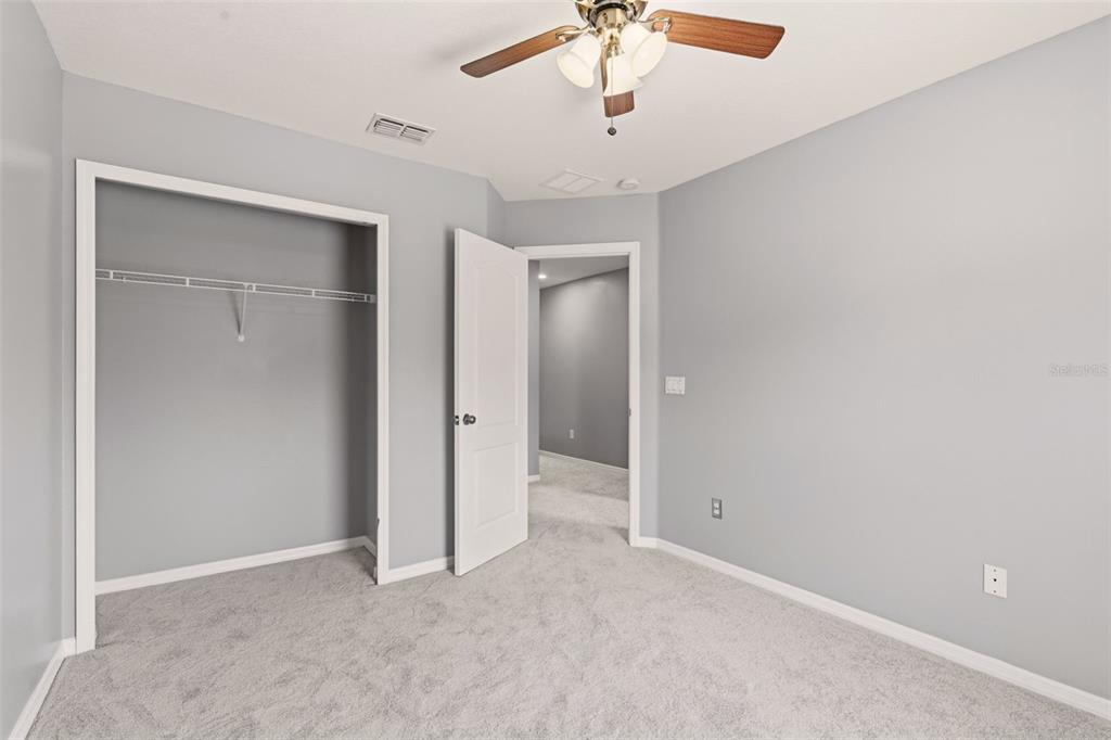 253 Bella Rosa Circle Sanford, FL 32771 - Photo 19 of 22 an empty room with a chandelier fan and closet area