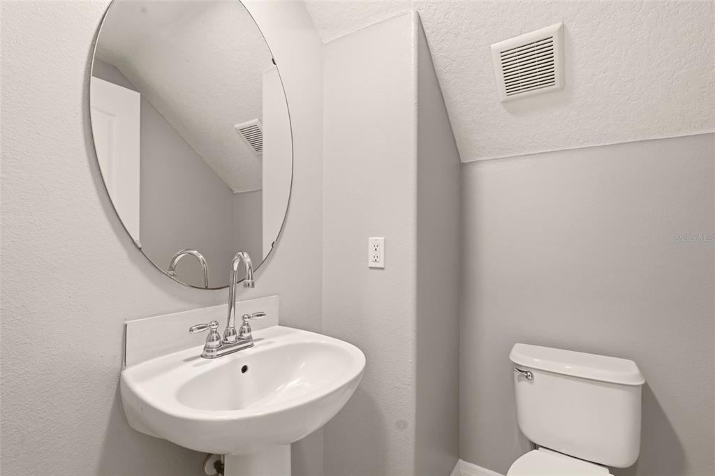 253 Bella Rosa Circle Sanford, FL 32771 - Photo 20 of 22 a bathroom with a toilet a sink and mirror