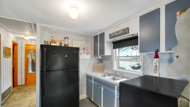 a kitchen with a refrigerator and a sink