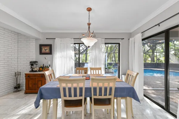 a dining room with furniture a chandelier and wooden floor