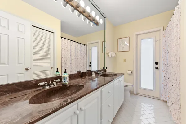 a bathroom with a granite countertop sink and a large mirror
