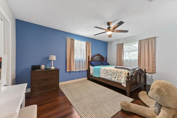 a bedroom with a bed and wooden floor