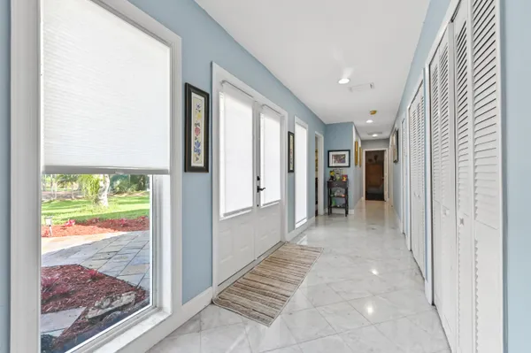 a view of a hallway with wooden floor and windows