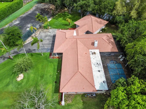 an aerial view of residential houses with outdoor space and trees