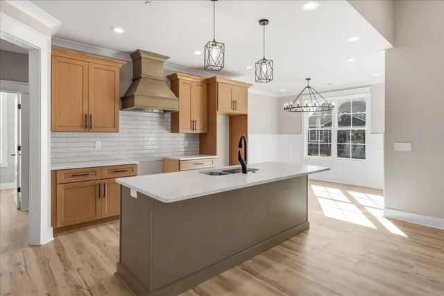 a large kitchen with kitchen island a stove a sink a center island and wooden floor