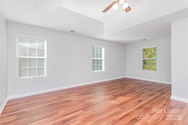 an empty room with windows and wooden floor