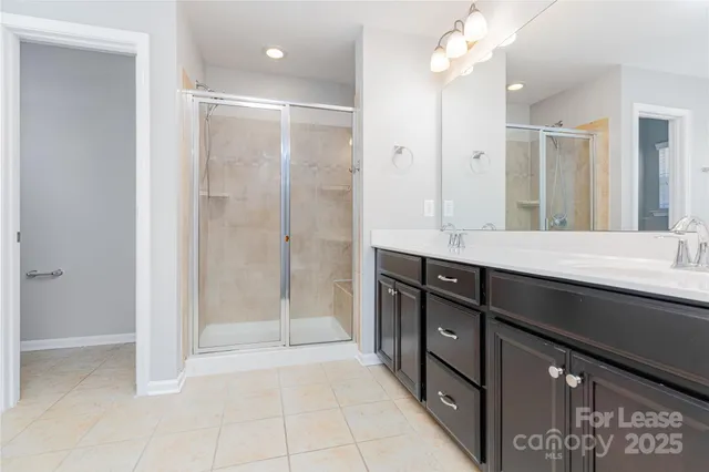 a bathroom with a granite countertop sink a large mirror and a shower