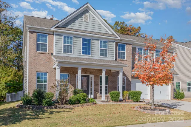a front view of a house with yard and green space