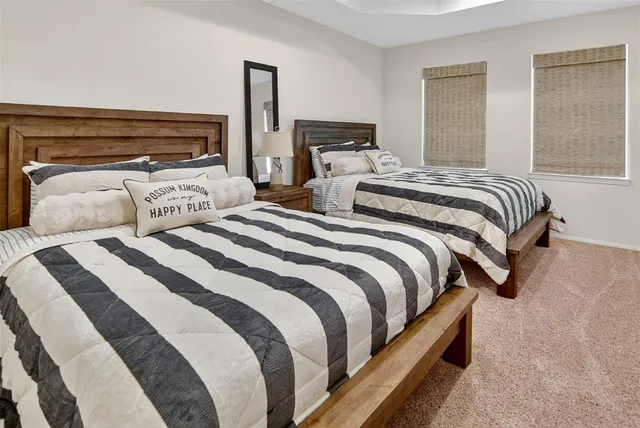 a bedroom with two beds lamp and a fireplace