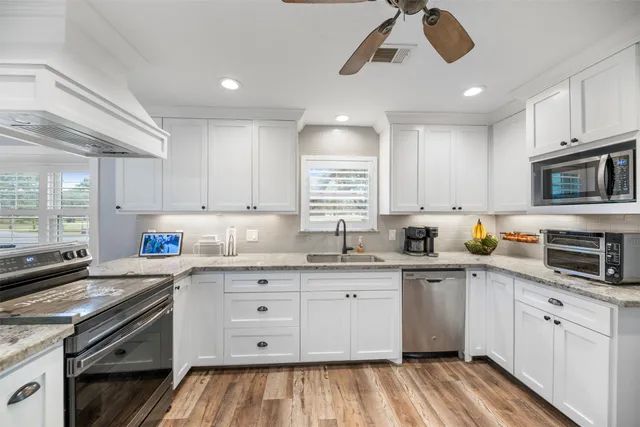 a kitchen with stainless steel appliances a sink stove and cabinets