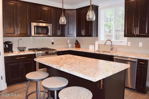 a kitchen with a table chairs sink and cabinets