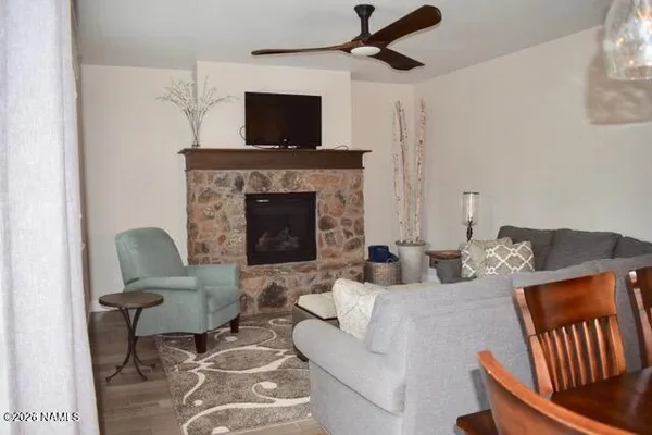 a living room with furniture a flat screen tv and a fireplace