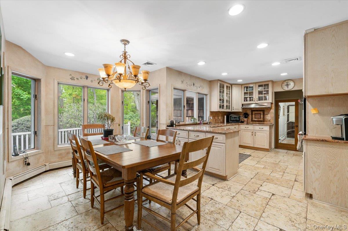 6 Apex Road Melville, NY 11747 - Photo 18 of 50 a dining room with stainless steel appliances a table and chairs in it