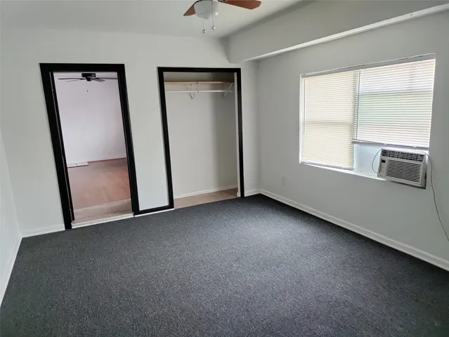 an empty room with windows and closet