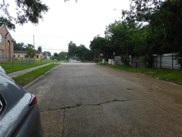 a view of a street with a house in the background