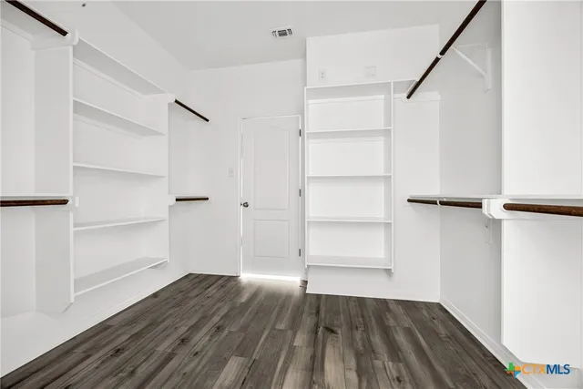 a view of walk in closet with empty racks