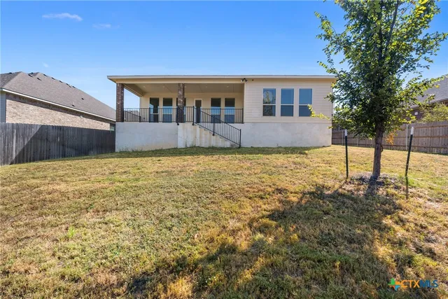 a view of an house with backyard space and balcony