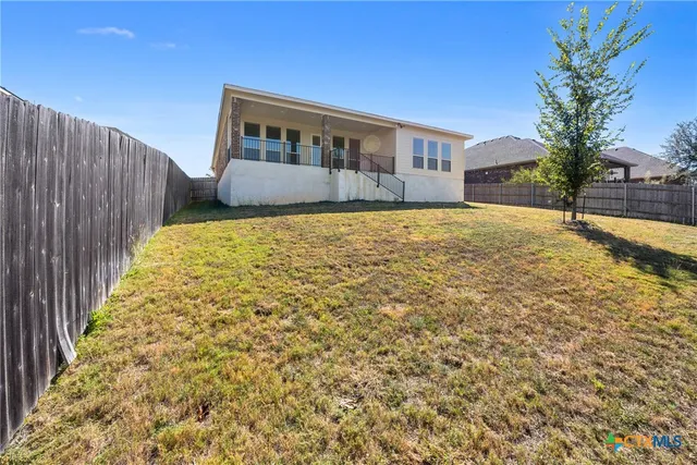 a house view with swimming pool and wooden fence