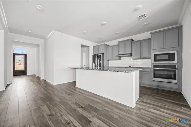 a view of kitchen with cabinets appliances and wooden floor
