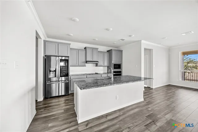 a large kitchen with a center island stainless steel appliances and cabinets