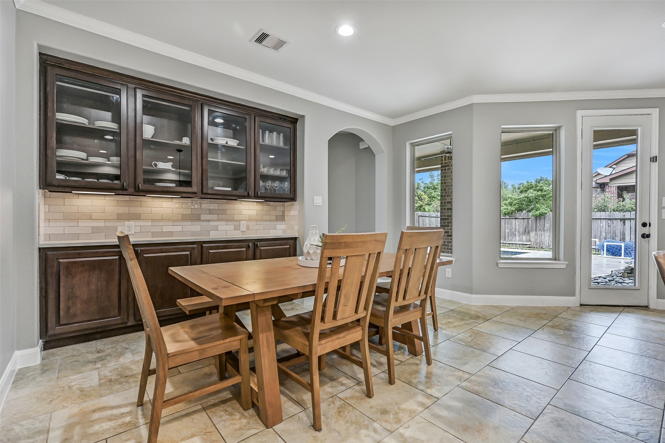 1008 Point Isabel Lane Friendswood, TX 77546 - Photo 20 of 50 A built-in buffet with glass front cabinetry adds storage and display space, along with a convenient serving area that enhances both functionality and design within the breakfast room.