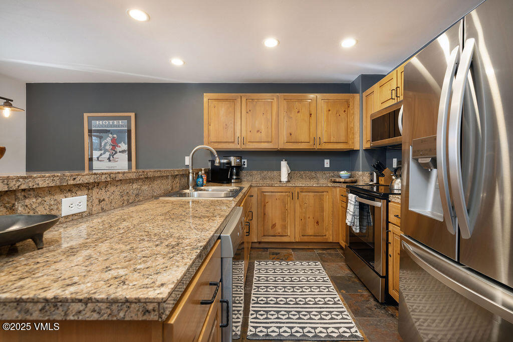 30 Cresta Road, Unit 308 Edwards, CO 81632 - Photo 4 of 9 a kitchen with stainless steel appliances granite countertop a stove a sink and a refrigerator