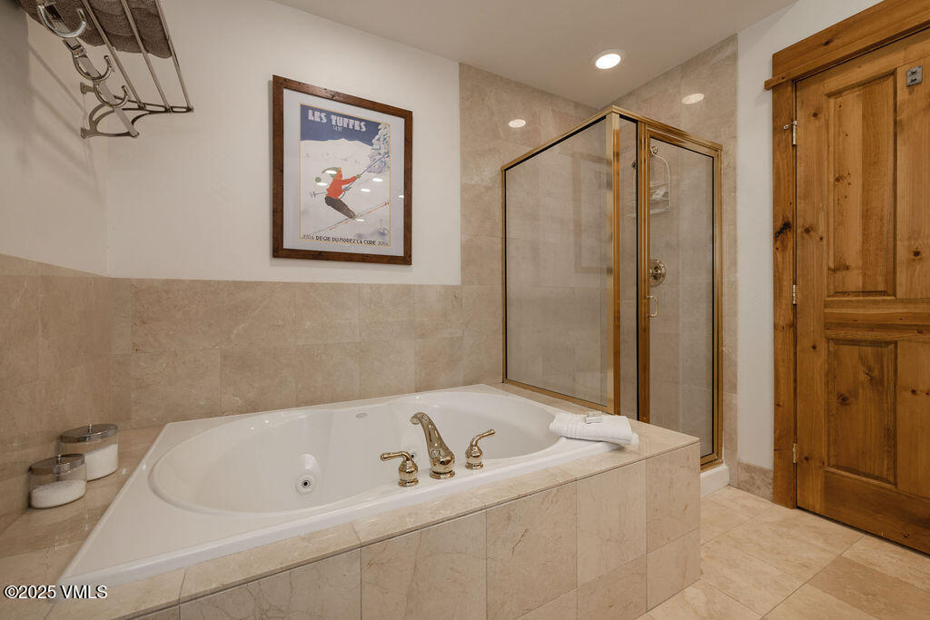 30 Cresta Road, Unit 308 Edwards, CO 81632 - Photo 9 of 9 a bathroom with a tub a sink and glass door