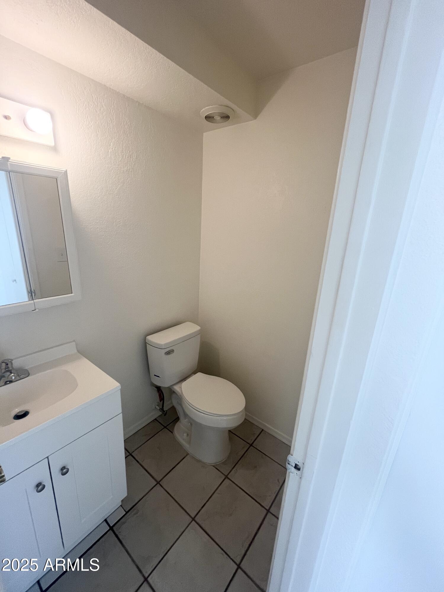 2075 11th Street Douglas, AZ 85607 - Photo 12 of 34 a bathroom with a toilet sink and mirror