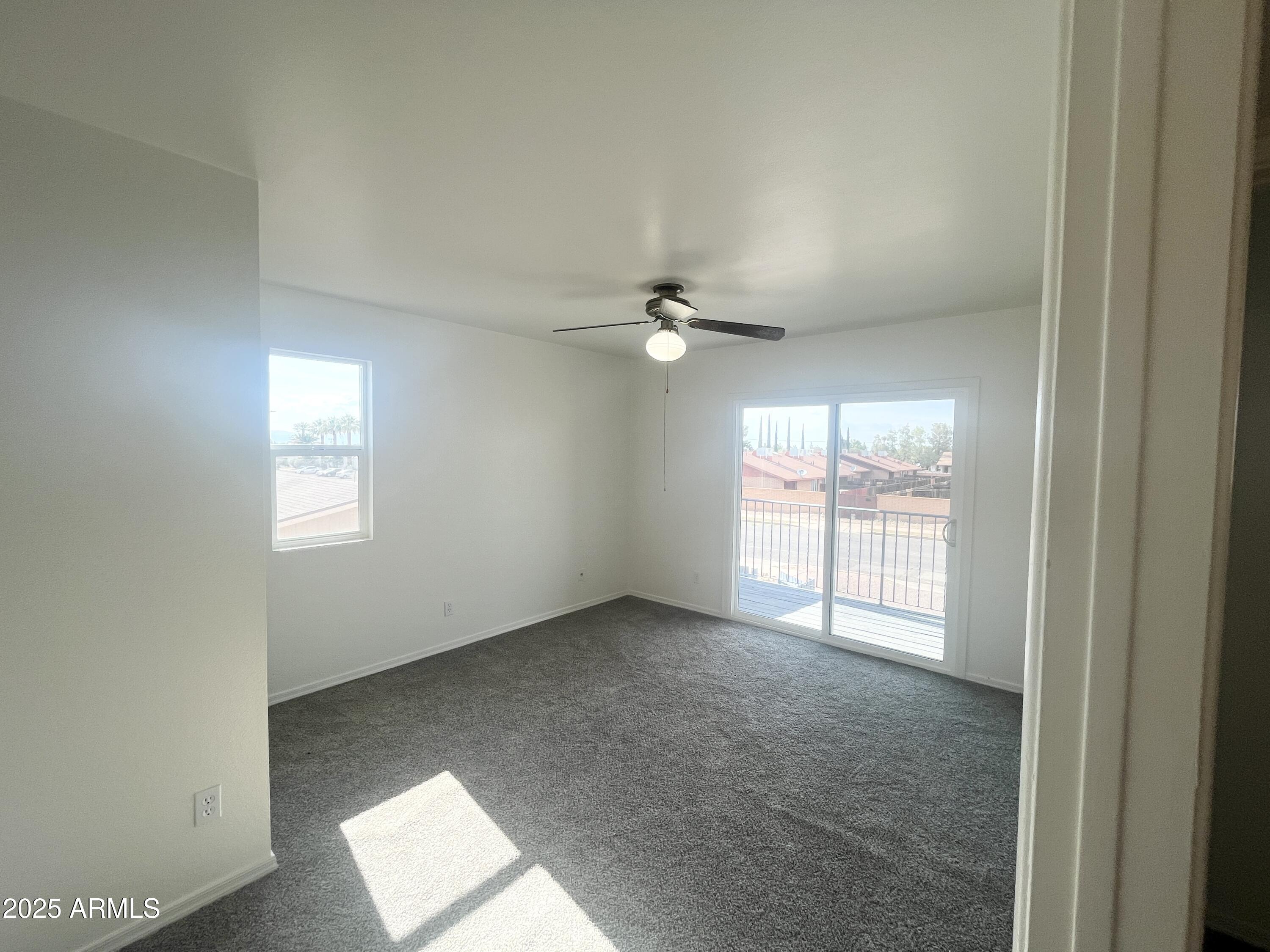 2075 11th Street Douglas, AZ 85607 - Photo 19 of 34 an empty room with chandelier fan and windows