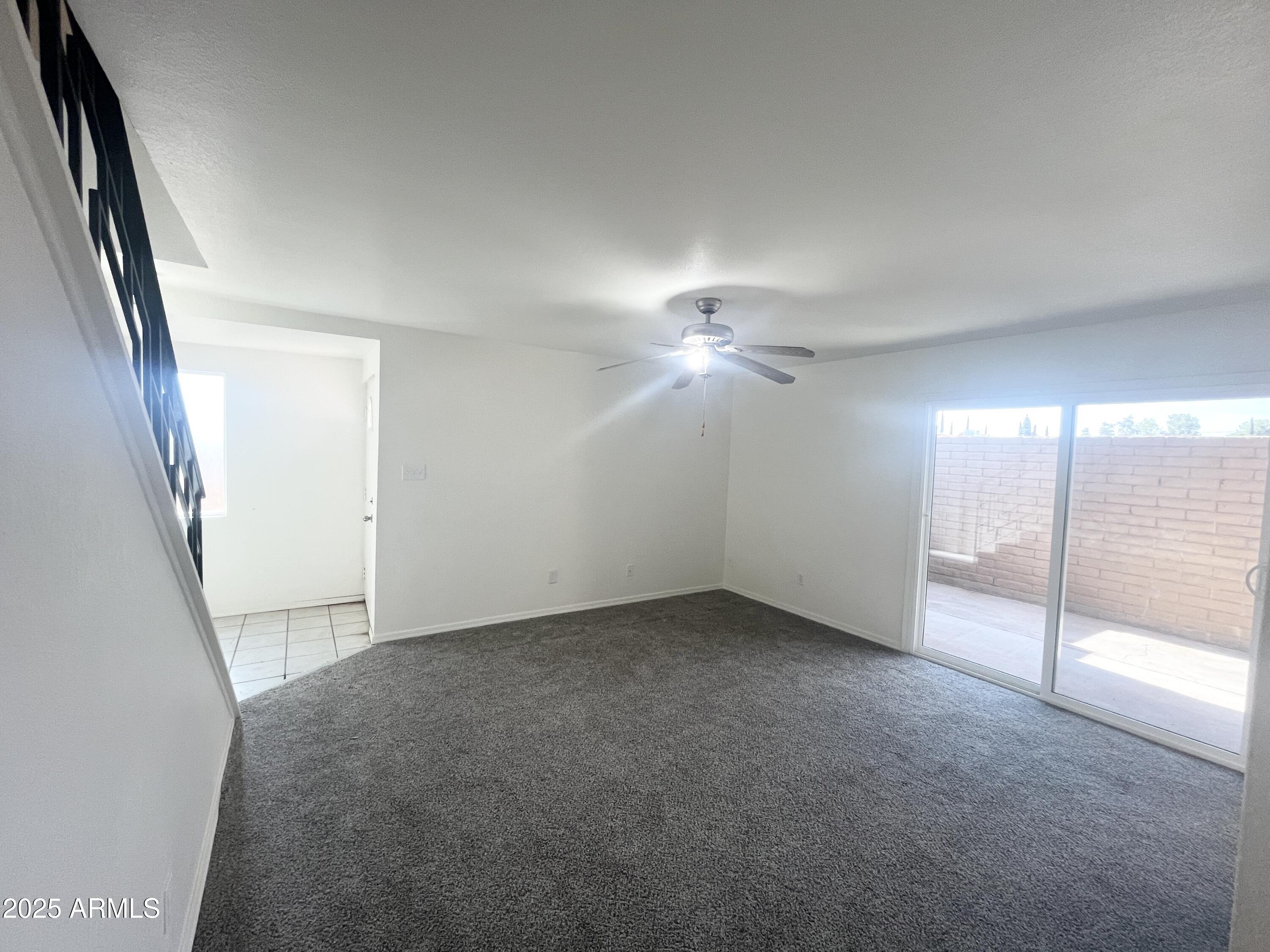2075 11th Street Douglas, AZ 85607 - Photo 5 of 34 an empty room with a ceiling fan and windows