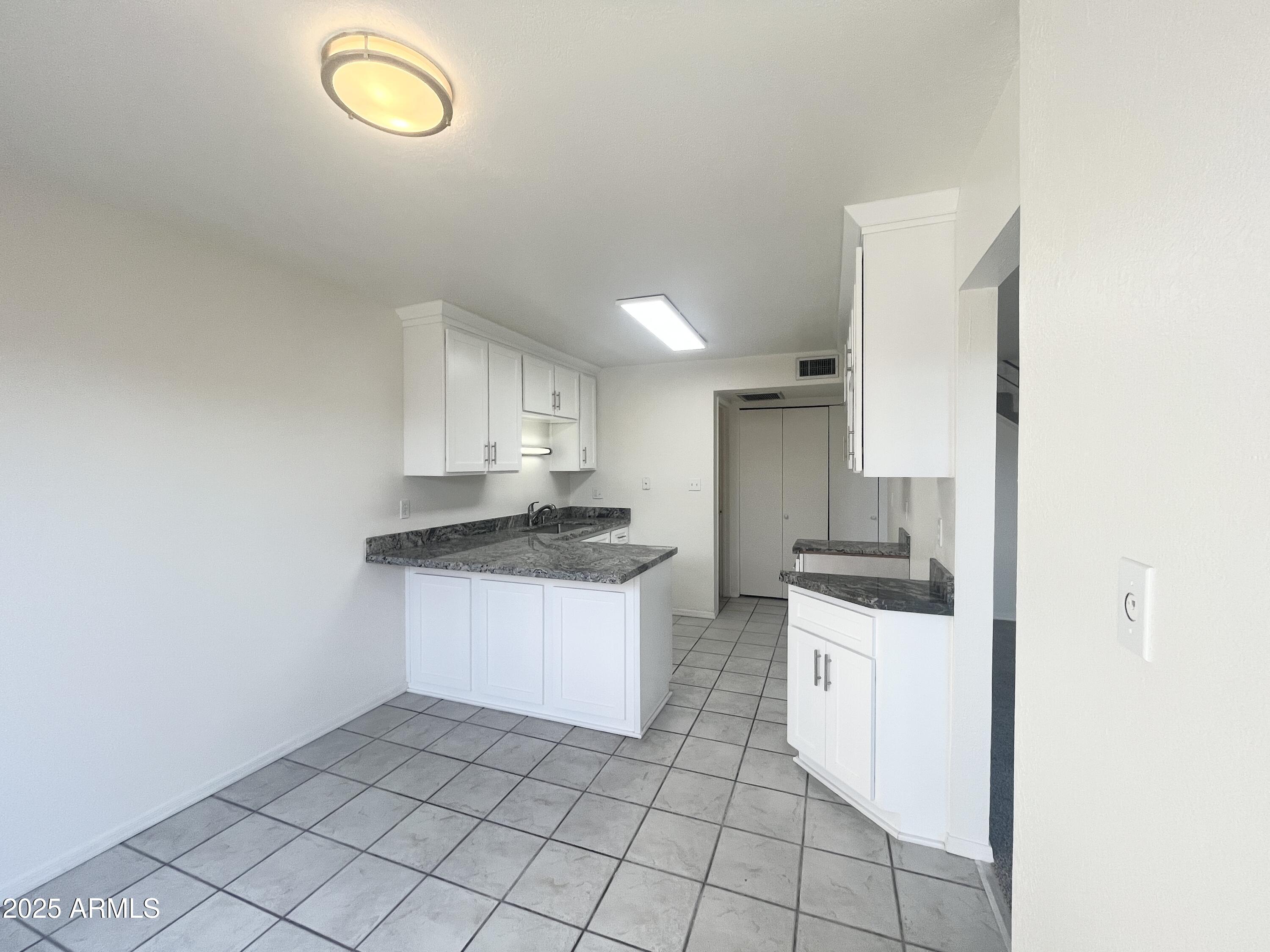 2075 11th Street Douglas, AZ 85607 - Photo 7 of 34 a kitchen with granite countertop a sink a stove and cabinets