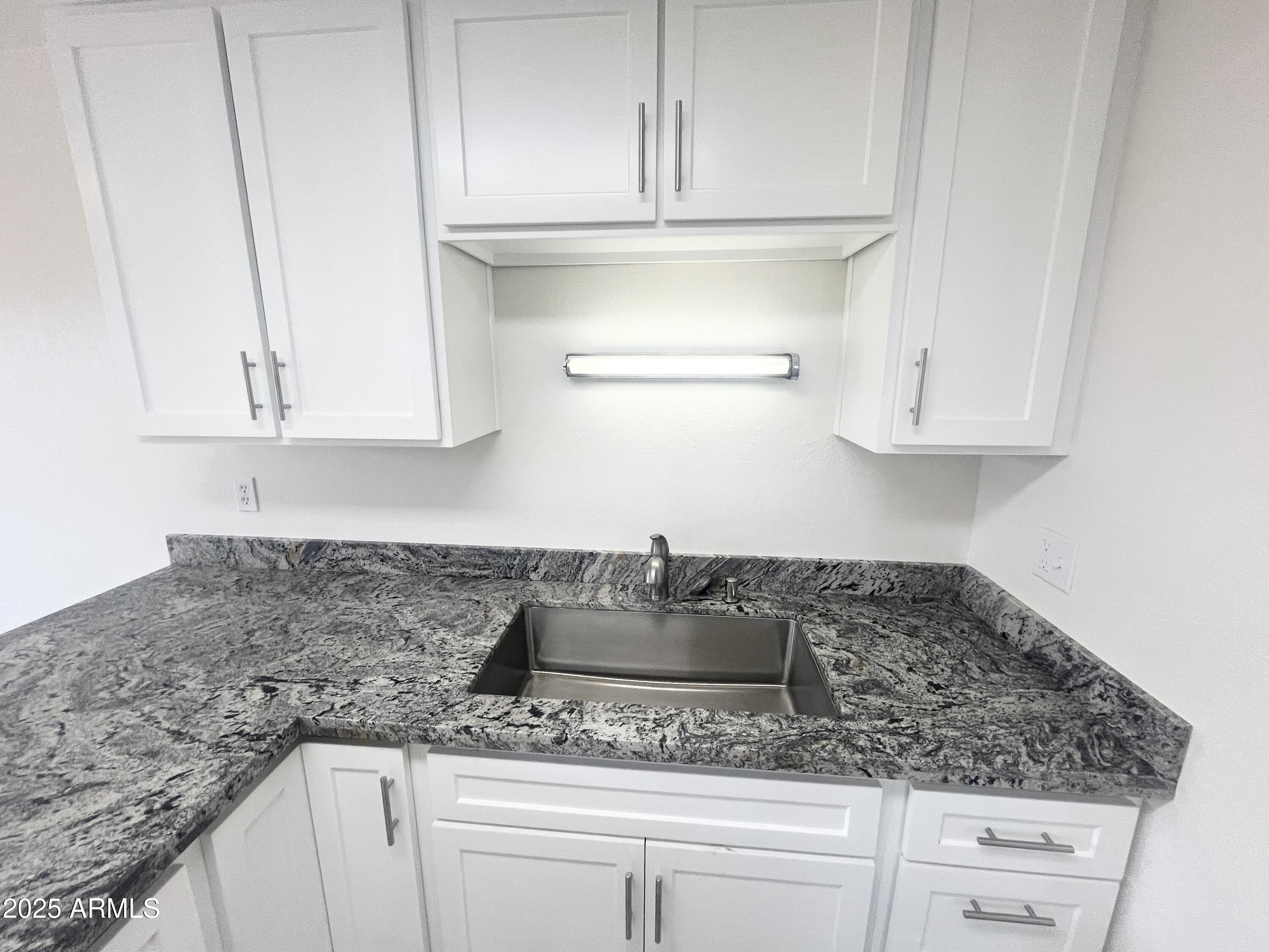 2075 11th Street Douglas, AZ 85607 - Photo 9 of 34 a kitchen with white cabinets and a granite counter tops