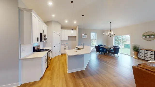 a large kitchen with cabinets a sink a counter space and stainless steel appliances
