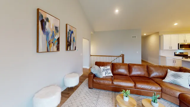 a blue couch sitting next to a blue wall with painting on the wall