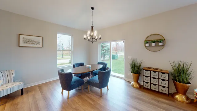 a dining room with furniture potted plants and wooden floor