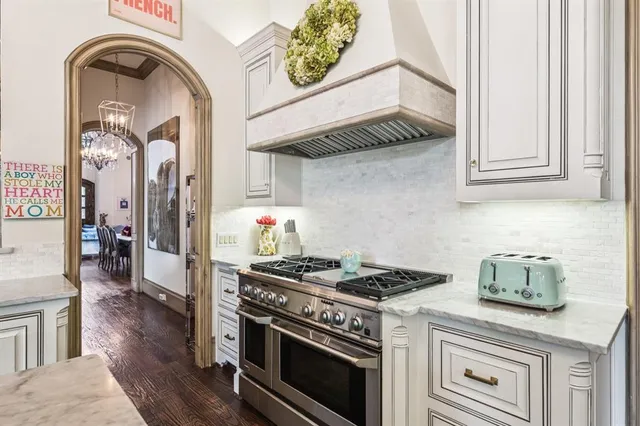 a kitchen with a stove and a wooden floor