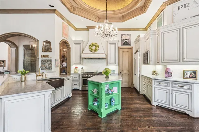 a large kitchen with stainless steel appliances a stove a sink dishwasher and cabinets with wooden floor