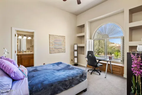 a bedroom with a bed and large windows