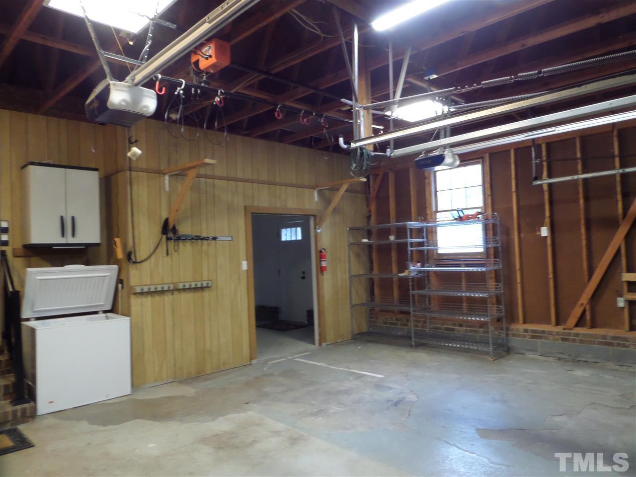 8725 Windjammer Drive Raleigh, NC 27615 - Photo 23 of 25 Large garage with storage options along with shelves and overhead with builtins and attachments Workshop or ofc.in separate area with own utility door-new garage dr openers.