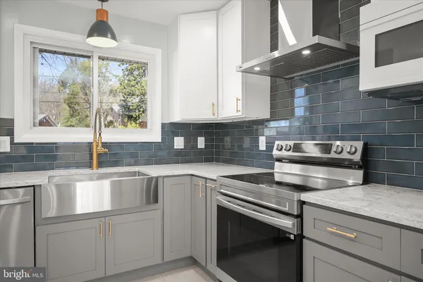 a kitchen with granite countertop a stove and white cabinets