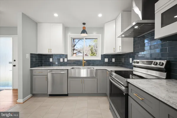 a kitchen with stainless steel appliances granite countertop a stove a sink and a microwave