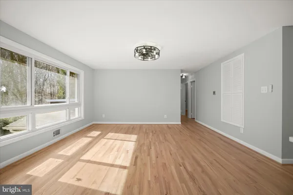a view of empty room with wooden floor