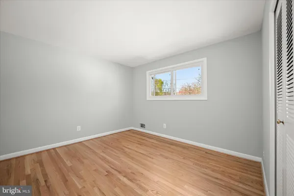 a view of a hallway with wooden floor and closet