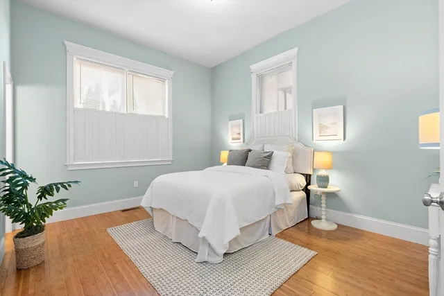 a bedroom with a large bed chandelier and a window