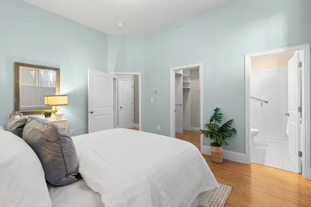 a bedroom with a bed and a potted plant