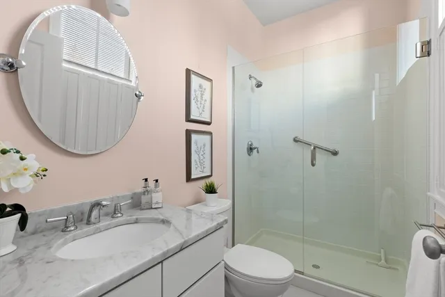 a bathroom with a granite countertop sink a mirror and a shower