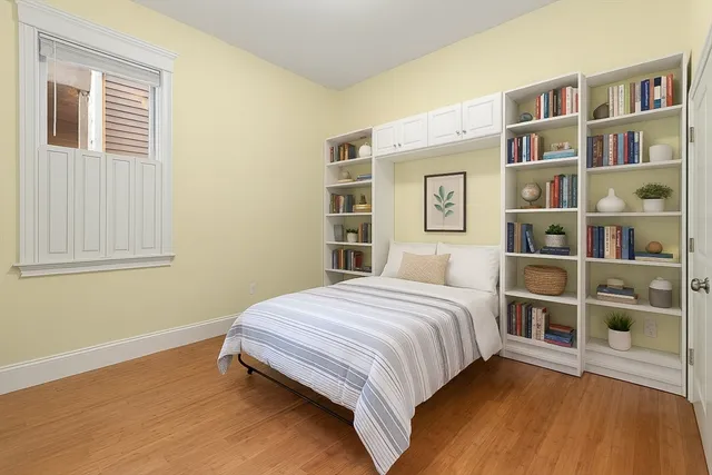 a bedroom with a bed and a book shelf